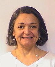 headshot photo of Teresa Mascarenhas smiling with medium length straight dark brown hair wearing a v-neck white top