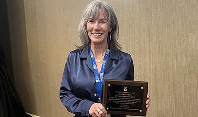 Christy Lyons holds her counselor educator of the year plaque.