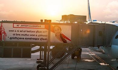 Graphics of a plane at a gate with a quote from Raphaella Pastos on the jetway saying "I’m really excited to be in a new country and a new culture and to just really experience everything"