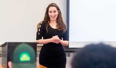 Sidita Kushi teaches a class in front of a white board.