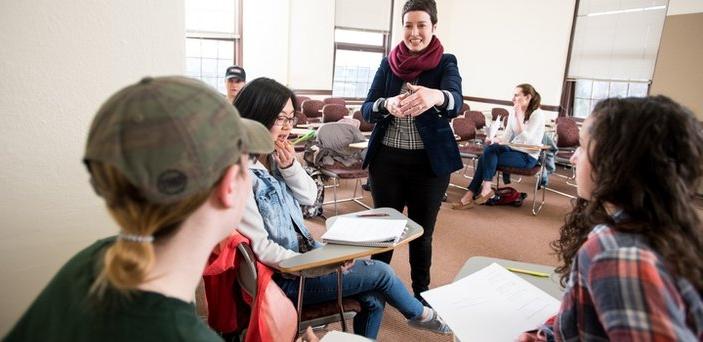 A professor talking to a small group in a class