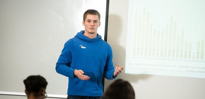 A student giving a presentation at projection screen in class