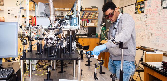 A BSU student working with photonics equipment in BSU photonics lab